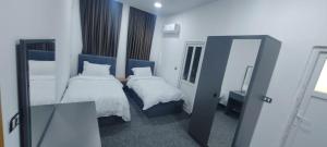 Motel beyza في السليمانية: غرفة نوم صغيرة بها سريرين ومرآة +7 صور