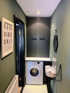 une petite salle de bains avec un lave-linge et un lavabo dans l'établissement Idyllic Barcombe cottage near South Downs National Park, à Barcombe Mills Station