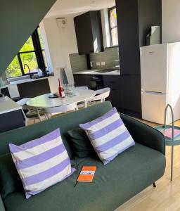 un canapé vert avec deux oreillers dans une cuisine dans l'établissement Idyllic Barcombe cottage near South Downs National Park, à Barcombe Mills Station