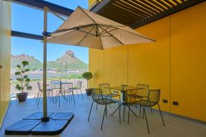a patio with tables and chairs and an umbrella at City Express by Marriott Guaymas in Guaymas