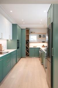 a kitchen with green cabinets and a wooden floor at Cape Loader House in Cape Town