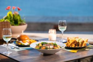 a table with plates of food and glasses of wine at Kenta Beach Hotel in Agios Ioannis Pelio
