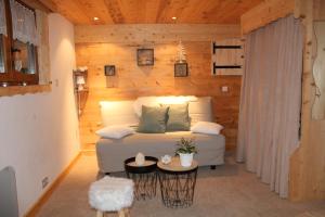 a living room with a white couch in a wooden wall at LA VARNACHE logement cosy in Bonvillard