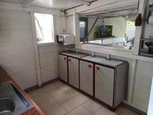 une petite cuisine avec un comptoir et un micro-ondes dans l'établissement La kaz créole, à Bouillante 9 autres photos