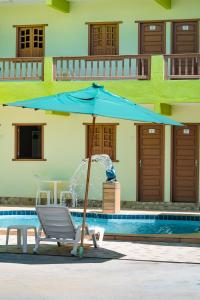 Una sombrilla azul junto a una piscina. en Pousada Ouriço, en Porto de Galinhas 87 fotos más