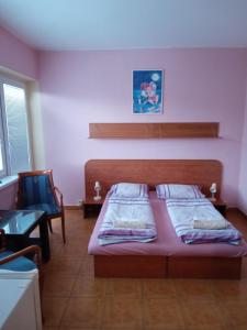 a bedroom with a bed and a chair at Garni Hotel Sonata in Trenčianske Teplice