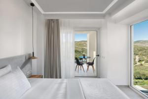 a bedroom with a bed and a table and a window at Myzith Luxury Suites in Keri