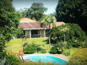 a house with a swimming pool in front of a yard at Karri Forest Motel in Pemberton