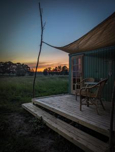 a wooden deck with a table and chairs on a house at Bienenwagen Weitblick, Kamin, Sauna ganzjährig nutzbar in Dargun