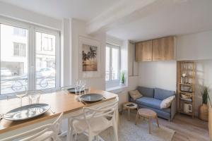 een keuken en woonkamer met een tafel en stoelen bij Oscaria, centre Reims, plein pied in Reims