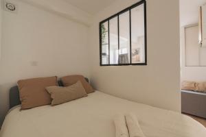 een slaapkamer met een groot bed met een raam bij Oscaria, centre Reims, plein pied in Reims