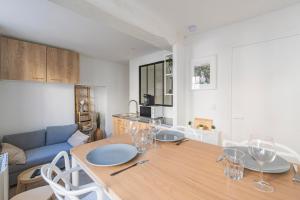 een woonkamer met een houten tafel met wijnglazen bij Oscaria, centre Reims, plein pied in Reims +15 foto's