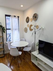 ein Wohnzimmer mit Tisch und Fernseher in der Unterkunft Chic One Bedroom Retreat in Downtown Manhattan in New York