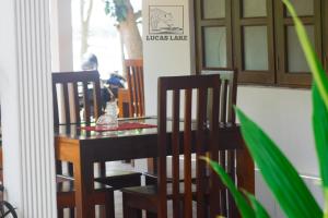 a dining room table with two chairs and a table with a vase at Yala Lucas Lake Hotel in Tissamaharama