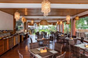 a restaurant with tables and chairs and chandeliers at Hotel Pousada Villa Zena - Frente ao Mar - Pé na areia in Arraial d'Ajuda