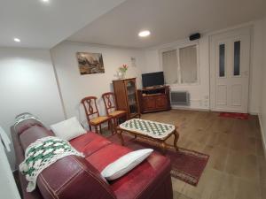 a living room with a couch and a tv at La tranquillité in Bourges