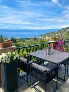 een tafel op een balkon met uitzicht op de oceaan bij casa lella home in Recco