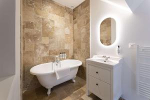 a bathroom with a white tub and a sink at Maison Castel A haven of peace near Deauville in Cricquebœuf