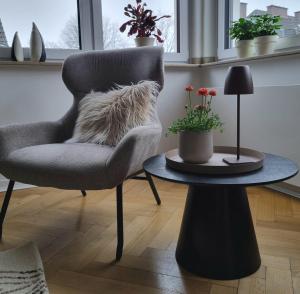 a living room with a chair and a table at Im Zentrum von Leverkusen, helle 3-Zimmerwohnung 80 m2 in Leverkusen