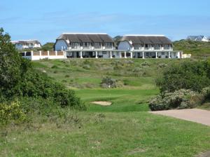 a golf course with houses on a hill at St Francis Golf Lodge in St Francis Bay