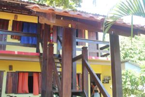 a wooden structure in front of a building at Pousada Arco Íris in Conceição da Barra