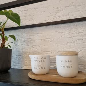 two coffee mugs sitting on a wooden tray at Im Zentrum von Leverkusen, helle 3-Zimmerwohnung 80 m2 in Leverkusen