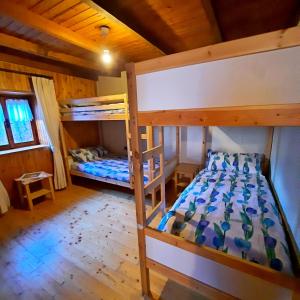 ein Schlafzimmer mit zwei Etagenbetten in einer Hütte in der Unterkunft Chalet Casargo in Casargo