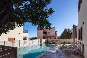 AtsipopouloにあるPROVILLAS - Ι, ΙΙ & ΙΙΙ - Luxury Villas with private pool near Retrymnoの椅子と家のあるプール