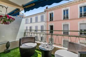 a balcony with wicker chairs and a table at Luxury Studio YourHostHelper in Cannes