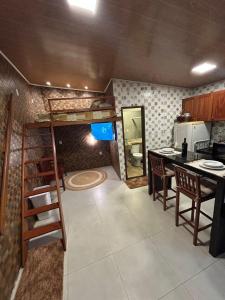 a room with a loft bed and a kitchen at 09 Kitnet próximo da praia com ar-condicionado in Maceió