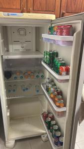 an open refrigerator filled with food and drinks at 09 Kitnet próximo da praia com ar-condicionado in Maceió