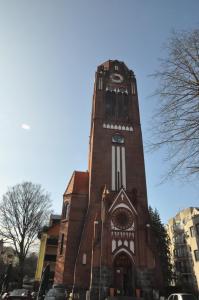 un edificio alto de ladrillo con una torre de reloj en Apartament Joanna, en Świnoujście