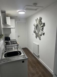 a kitchen with a sink and a mirror on the wall at Fully Refurbished 3 Bed Terraced House with Ensuite Central Rugby in Rugby