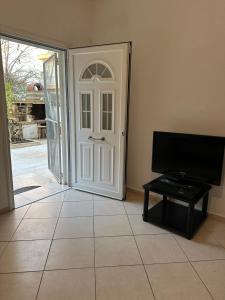 a room with a white door and a tv at GRILL&SEA apartments in Perea