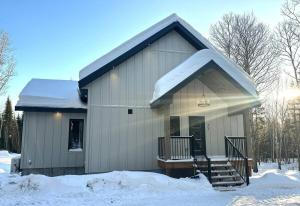 une petite maison avec de la neige sur le toit dans l'établissement Cottage Quebec - L'Eclipse Nordique, à Petite-Rivière-Saint-François 9 autres photos