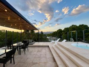 a patio with a table and chairs and a swimming pool at La Sofia Apart & Wines in Mendoza