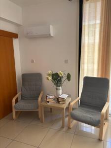 two chairs and a table in a room at VIP Resort Apartment on Makenzie Beach in Larnaca