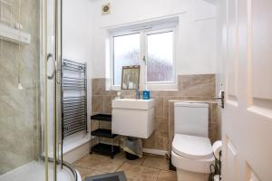 a bathroom with a toilet and a sink and a window at 2Bed Mid Terrace Close To Station in Stoke on Trent