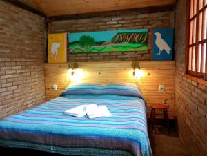 圣罗克迪米纳斯Camping Carcará da Canastra的卧室里有一张床，床上放着两条毛巾。