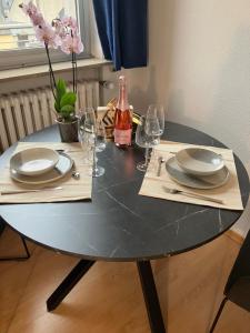 a table with plates and glasses and a bottle of wine at Unique Penthouse Joseph II von Habsburg 1-4 personnes à coté de Louis Vuitton in Luxembourg