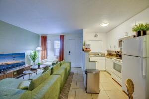 a living room with a green couch and a kitchen at Vibrant Modern Escape, Walk To Dining, Near Beach in Sarasota