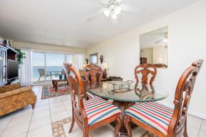 a dining room with a glass table and chairs at Driftwood Towers 5E in Gulf Shores