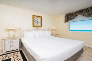 Un dormitorio con una gran cama blanca y una ventana. en Driftwood Towers 5E condo, en Gulf Shores 23 fotos más