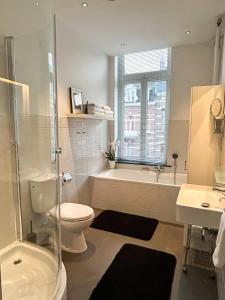 Un baño con bañera, inodoro y lavabo. en B&B Alexander, en Maastricht