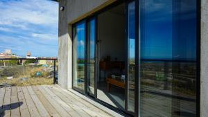 a balcony with glass doors and a bench on a deck at Chaparisco in Puerto Madryn