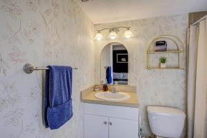a bathroom with a sink and a blue towel at Vibrant Modern Escape, Walk To Dining, Near Beach in Sarasota