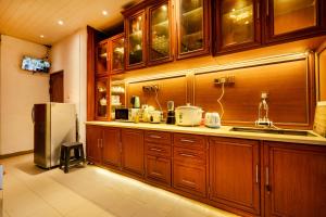 努沃勒埃利耶Villa Grand Mellow Nuwara Eliya的厨房配有木制橱柜和冰箱。