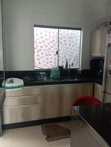 a kitchen with a sink and a window at Casa Completa in Cascavel