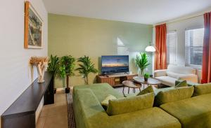 a living room with a couch and a tv at Vibrant Modern Escape, Walk To Dining, Near Beach in Sarasota