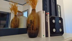 two vases sitting on a table next to two books at VOYAGE AU CALME à 10 Minutes du centre avec PARKING INCLUS et FIBRE, IDÉAL SOLO et PRO in Rouen
